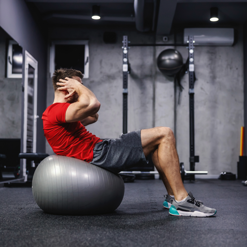 Man lifting weights in the gym while training for fat loss and muscle growth
